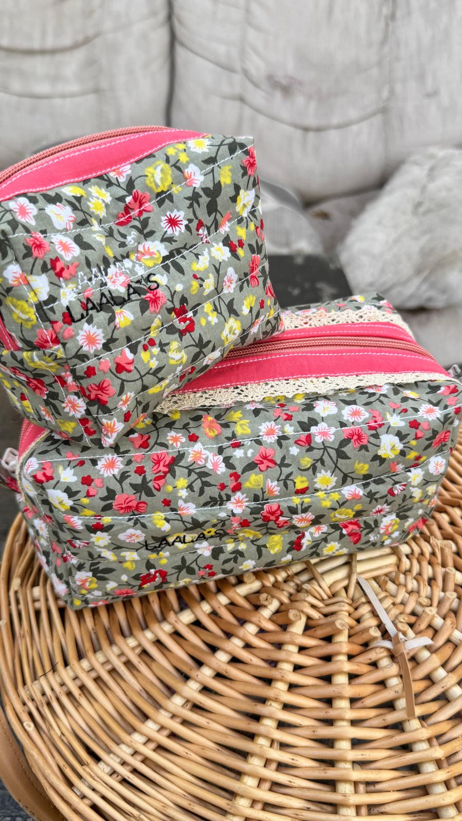 Two personalised grey-green quilted pouches with colourful flowers, pink zippers and lace trim